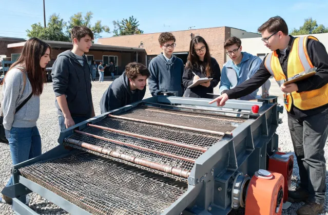 Students inspecting donated vibrating screen